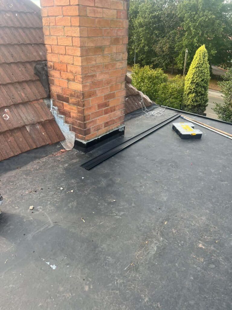 This is a photo of a flat roof which has just been repaired, there is also a chimney stack and some leadwork has also been dressed. Works carried out by MCM Roofing Repairs Blandford Forum